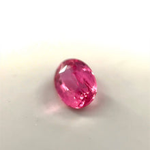 Oval cut Padparadscha sapphire showing brilliant luster and faceting under daylight
