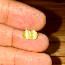 Close-up of 2.18ct twin cat’s eye gemstone with translucent honey-yellow color and distinct twin rays.