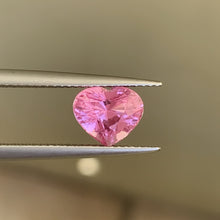 Close-up of natural heart-cut Padparadscha sapphire showing pink-orange color blend and precision faceting