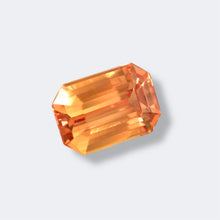 Emerald cut Padparadscha sapphire showing brilliant luster and faceting under daylight