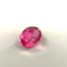 Oval cut Padparadscha sapphire showing brilliant luster and faceting under daylight