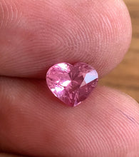 Natural Padparadscha sapphire heart-cut 2.13 ct shown in hand to illustrate size, color, and clarity in natural daylight